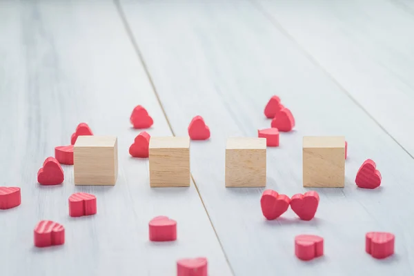 Stack of blank wood cube with group of mini red heart on white r — Stock Photo, Image