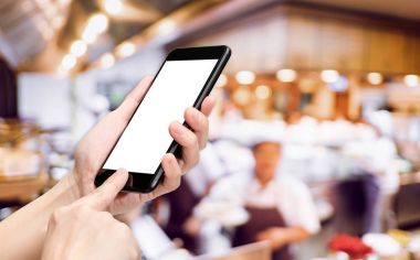 El tıklatın Restoran arka plan bulanıklık aşçı ile cep telefonu 