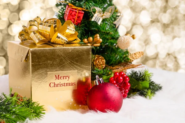 Shiny gold gift box with Merry Christmas word with red decoratio — Stock Photo, Image