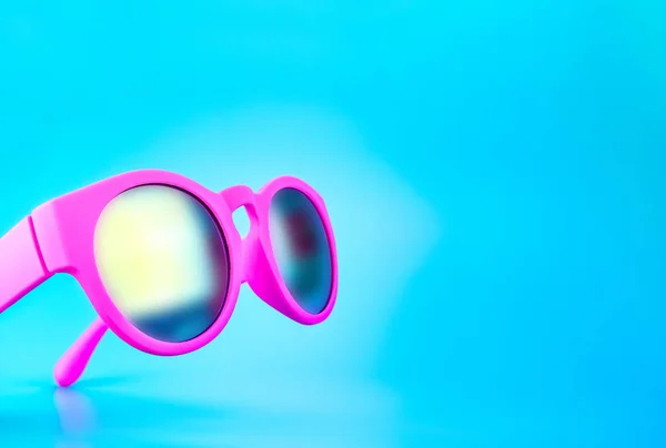Impactantes gafas de sol de color rosa en el fondo del estudio azul claro, S — Foto de Stock