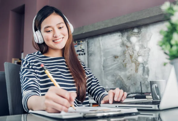 Giovane asiatica casual businesswoman ascolto musica e scrittura rep — Foto Stock