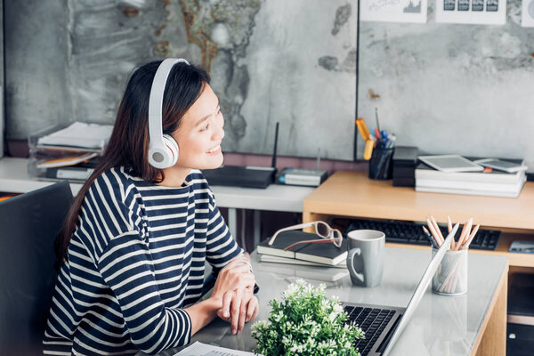 Young asian casual businesswoman arm on desk rest pose with lapt