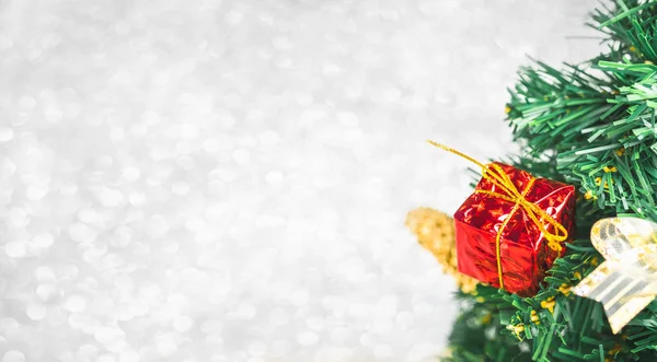 Close up red gift box on green Christmas tree at white bokeh lig — Stock Photo, Image