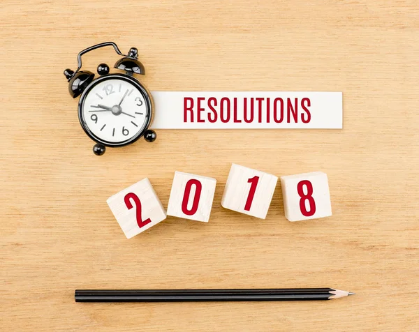 Resoluções 2018 ano novo vermelho no cubo de madeira com lápis e relógio — Fotografia de Stock
