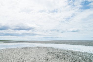 Ebb gelgit bulutlu gökyüzü ve su gökyüzü yansıması ile denizde