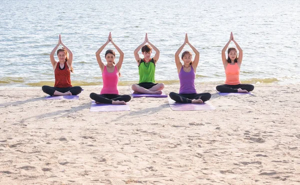 Yoga sınıf deniz sahilinde akşam, bir grup insan ağaç p yapıyor