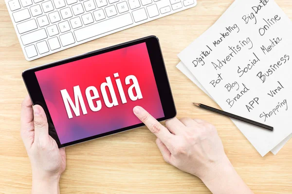 Mão usando tablet com palavra de mídia na tela com lista de digital — Fotografia de Stock