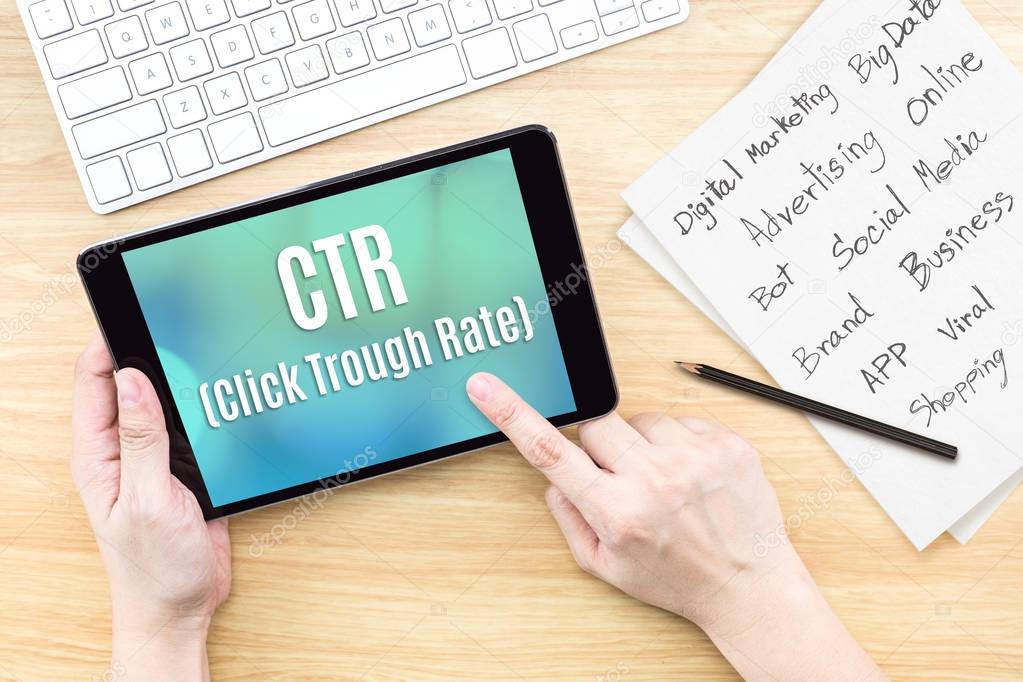 Hand using tablet with CTR ( Click trough rate ) word on screen 