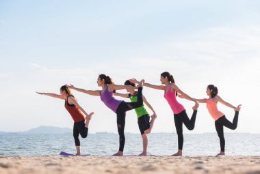 Yoga sınıf deniz sahilinde akşam, bir grup insan Lord o yapıyor