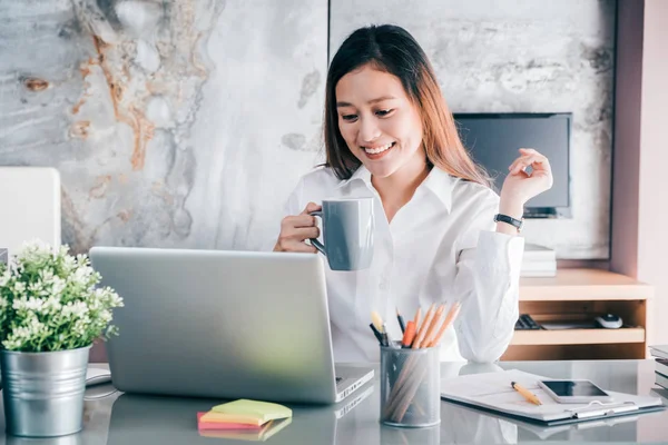 Asiatiska affärskvinna ta en fika efter att ha arbetat på laptop — Stockfoto