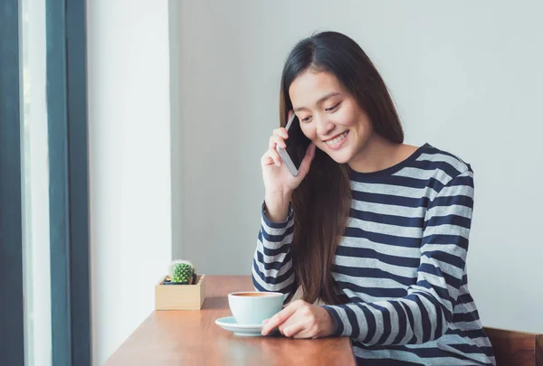 Asiatico donna parlando su cellulare e seduta a caffè restaura — Foto Stock