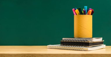 Ahşap masa w çalışma not defteri yığınını kutusunda renkli kalem