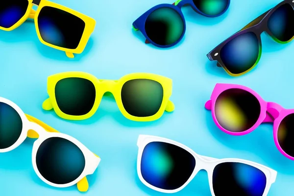 Conjunto de gafas de sol yacen en estudio de suelo azul, concepto de verano — Foto de Stock