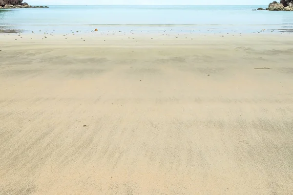 Cerca de la ola en la playa de arena con el mar borroso en el fondo —  Fotos de Stock