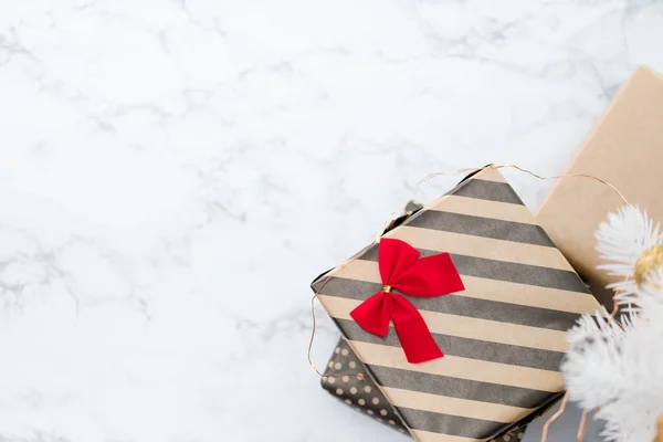 Top view of modern striped present box with red bow lay under wh — Stock Photo, Image