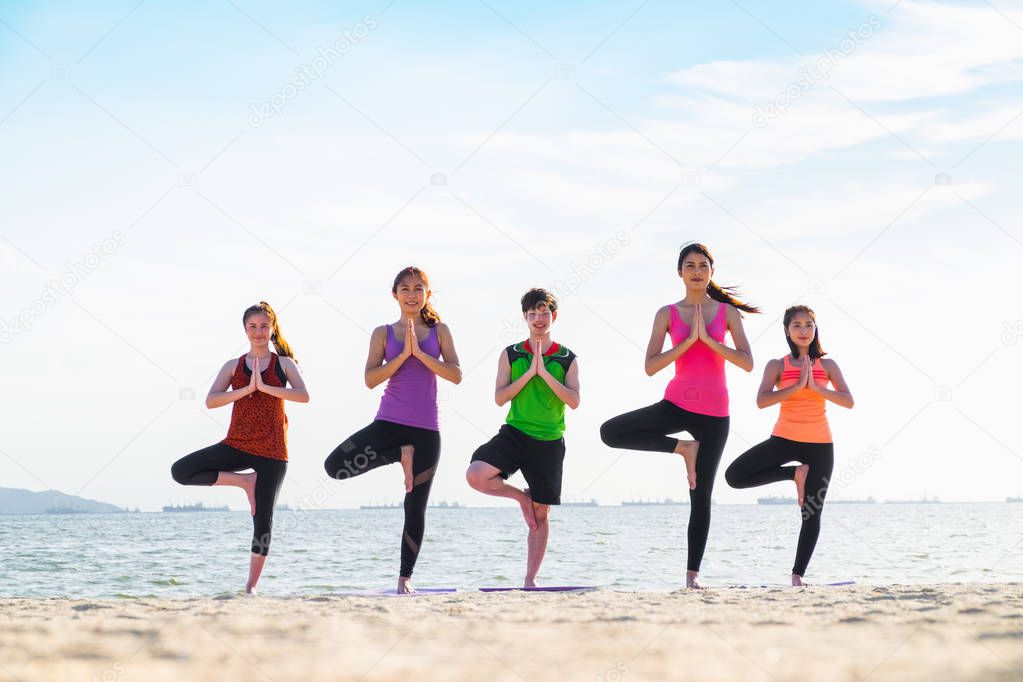 yoga group of people doing tree pose and namaste with calm relax
