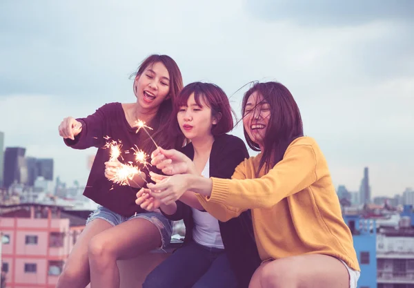 愉快的亚洲女孩朋友小组享受和演奏烟火在屋顶 — 图库照片
