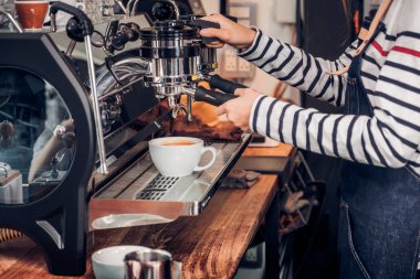 Kadın barista makine sayaç ile sıcak kahve kapatmak