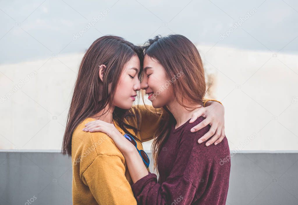 Asia lesbian LGBT Couple hug and nose kiss on rooftop of buildin