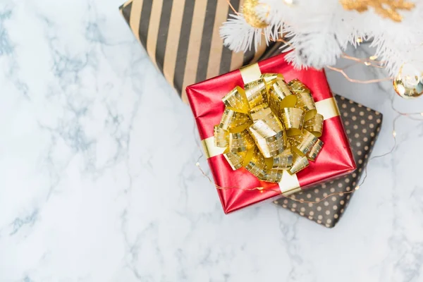 Top view of red glossy present box with golden bow and ribbon la — Stock Photo, Image