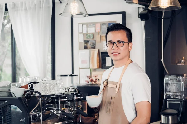 Masculino barista café proprietário segurando xícara de café na loja balcão — Fotografia de Stock