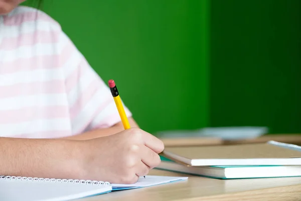 Молода дівчина-підліток пише на ноутбуці домашнє завдання в бібліотеці в — стокове фото