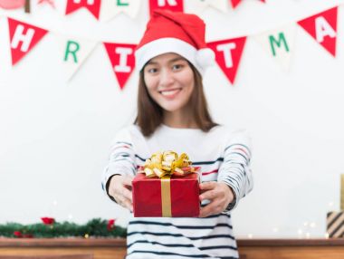 Asya kadın SMIL arkadaşıyla kırmızı kutu vererek xmas parti hediye