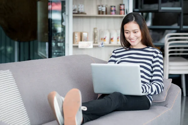 Asiatiska tonåring flicka använder bärbar dator och sitter korsa benen — Stockfoto