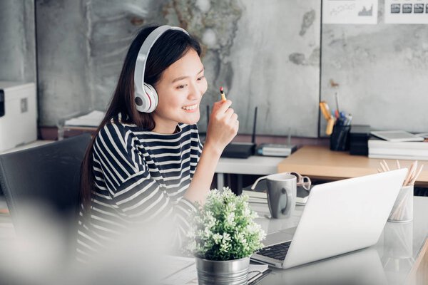 Young asian casual businesswoman arm on desk rest pose with lapt