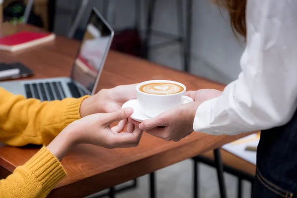 Mulher asiática barista segurando xícara de café servido ao cliente na guia — Fotografia de Stock