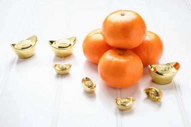 Çin yeni yılı, altın ingotlar ve Beyaz ahşap üzerine mandalina portakal