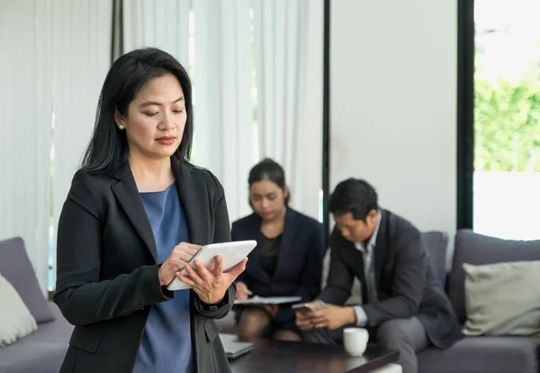 Empresa líder utilizando tableta con equipo en reunión corporativa —  Fotos de Stock