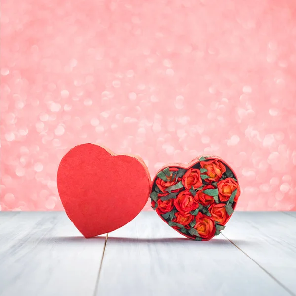 Boîte en forme de coeur avec des roses rouges à l'intérieur sur le dessus de table en bois blanc à — Photo