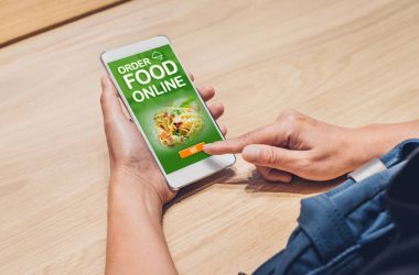 İnsanlar yiyecek online mobil apps ile evde ahşap masa üzerinde sipariş.,