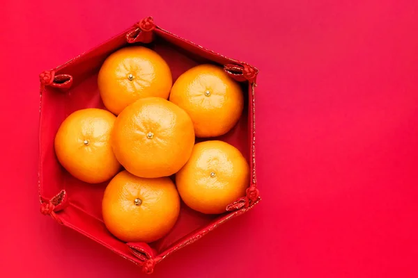 Groupe de mandarine orange en plateau motif chinois sur table rouge t — Photo