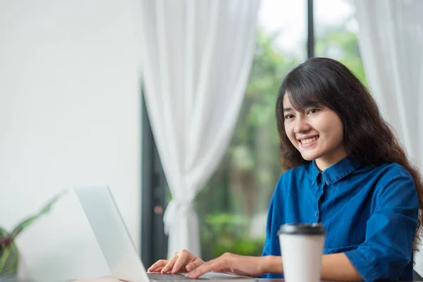 Asiatico donna utilizzando su computer portatile vicino finestra a caffè restaur — Foto Stock