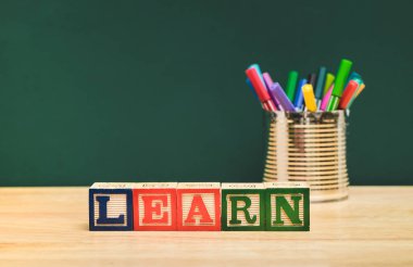 Ahşap blok ve kalem kutusu yeşil blackbo ile ahşap masa üzerinde bilgi edinin