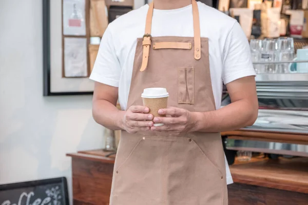 Azië barista ober slijtage schort holding heet klaarmaaltijden koffiekopje — Stockfoto