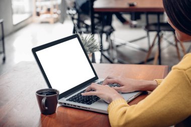 Asyalı kadın dizüstü bilgisayar yapmak online aktivite üzerinde ahşap sekmesini kullanarak