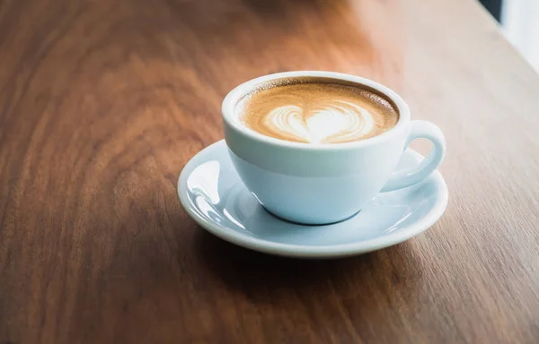 Cerrar taza de café capuchino caliente con forma de corazón arte latte en — Foto de Stock