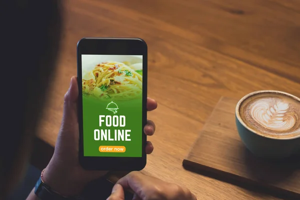 Закрыть руку женщина держит еду онлайн мобильные приложения с горячей Cof — стоковое фото