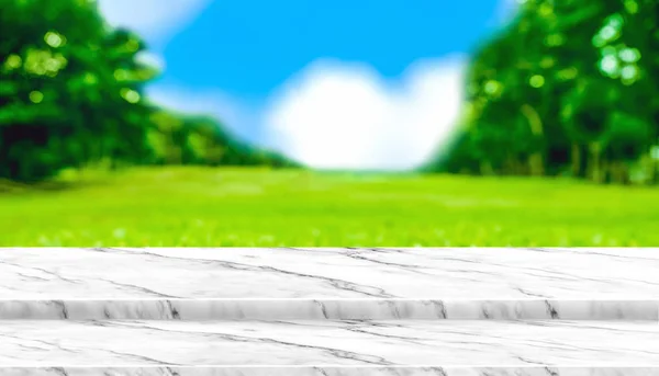 Tampo de mesa de mármore branco vazio com campo de grama desfocada no parque com — Fotografia de Stock