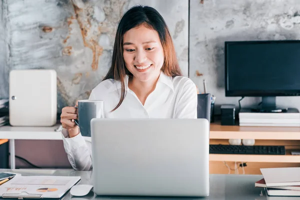 Asiatico businesswoman prendere un caffè pausa dopo lavoro a laptop — Foto Stock