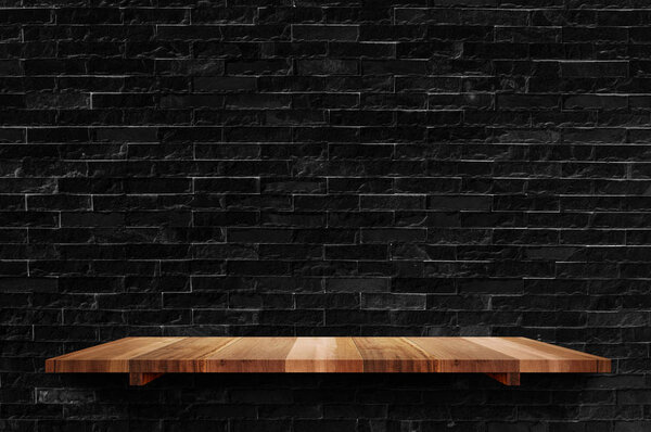 Empty wood board shelf at black brick wall background,Mock up fo
