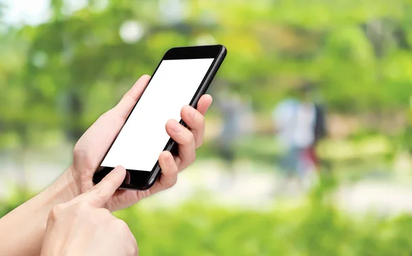 Kézzel mozgatható telefon-val blur zöld fa háttér bokeh li kattintson — Stock Fotó