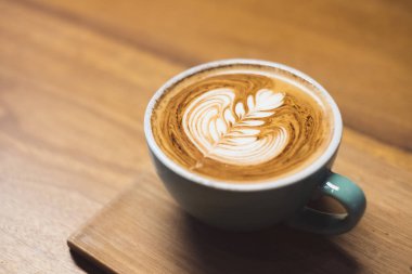 Kalp şekli latte sanat ile sıcak cappuccino kahve fincan kadar yakın