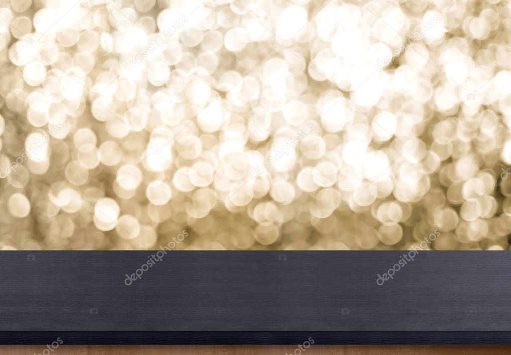 Empty old rustic black wood table top with blur sparkling gold b