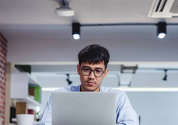 Азиатский бизнесмен с ноутбуком и бумажной работой на столе в — стоковое фото