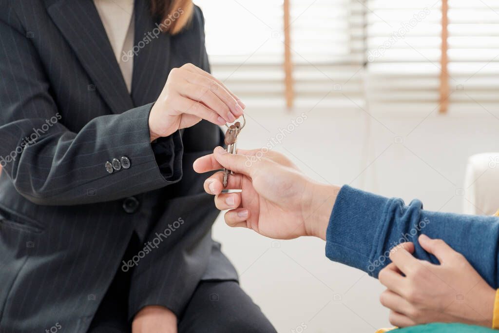 Asian happy couple getting key and handshake with realtor agent with smiling face at new home.buying new house real estate