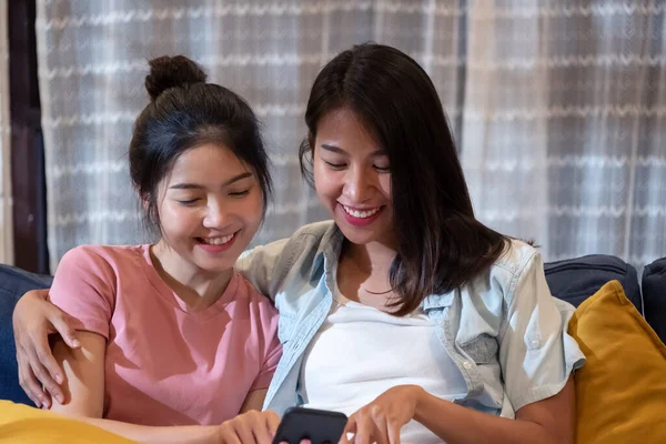 Щаслива Азіатська Пара Лесбіянок Дивиться Відео Мобільний Телефон Разом Дивані — стокове фото